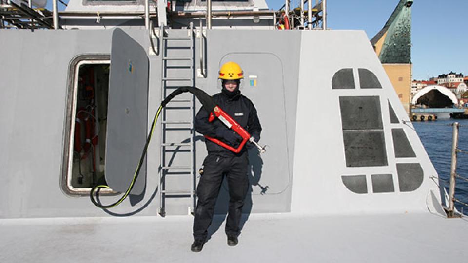 A firefighter holding a specialized Cobra Cold Cutter designed for fighting fires on ships. Photo by Cold Cut Systems (a CTIF Associate member)